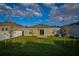 The backyard has a large grassy area and a sliding glass door at 214 Brave Rd, Davenport, FL 33837