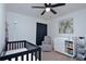 This Bedroom is well-lit and is decorated with a palm tree picture and a black crib at 214 Brave Rd, Davenport, FL 33837