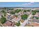 Aerial view of a residential neighborhood with a house featuring a screened-in pool at 214 Glasgow Ct, Davenport, FL 33897
