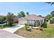 Well-kept single-story home featuring a two-car garage, solar panels, and manicured lawn at 214 Glasgow Ct, Davenport, FL 33897