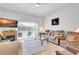 Bright living room features plush seating, fireplace, and sliding glass doors to the outdoor area at 214 Glasgow Ct, Davenport, FL 33897