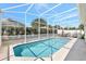 Inviting screened-in pool with clear blue water and outdoor seating at 214 Glasgow Ct, Davenport, FL 33897