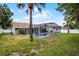 Well-maintained backyard with a screened-in pool area and tropical palm trees at 2203 Essex Dr, Ocoee, FL 34761