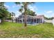 Spacious backyard featuring a screened-in pool, palm trees, and a well-maintained lawn at 2203 Essex Dr, Ocoee, FL 34761