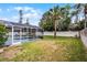 Lush backyard showcasing a screened-in pool area, tropical palm trees, and green lawn at 2203 Essex Dr, Ocoee, FL 34761