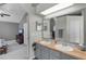Spacious bathroom with double sinks, wood countertops, decorative mirror, and open access to bedroom at 2203 Essex Dr, Ocoee, FL 34761