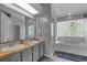 Bathroom with double sinks, a glass door shower, and a bathtub under a glass block window at 2203 Essex Dr, Ocoee, FL 34761