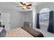 Bedroom with a large window, ceiling fan, and a dresser for ample storage space at 2203 Essex Dr, Ocoee, FL 34761