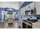 Open kitchen features stainless steel appliances, island seating, and white cabinets at 2203 Essex Dr, Ocoee, FL 34761