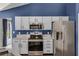 Modern kitchen features stainless steel appliances, white cabinets, and granite countertops at 2203 Essex Dr, Ocoee, FL 34761