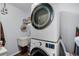 This laundry room showcases stacked washer and dryer units, plus a small sink and shelves for supplies at 2203 Essex Dr, Ocoee, FL 34761