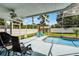 Screened-in pool area with lounge chairs, outdoor furniture, fan and a red umbrella in the background at 2203 Essex Dr, Ocoee, FL 34761