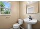 Well-lit half bathroom featuring modern fixtures, pedestal sink, and a window at 2488 Hassonite St, Kissimmee, FL 34744