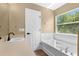 Bathroom with soaking tub, window, and a neutral color scheme at 2488 Hassonite St, Kissimmee, FL 34744