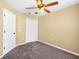 A cozy bedroom featuring neutral walls, a ceiling fan, and carpeted floors at 2488 Hassonite St, Kissimmee, FL 34744