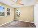 This bedroom has three windows, a ceiling fan, and carpeted floors at 2488 Hassonite St, Kissimmee, FL 34744