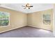 This is a primary bedroom featuring a ceiling fan and two windows for ample natural light at 2488 Hassonite St, Kissimmee, FL 34744