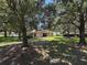 Lush backyard featuring an expansive grassy area and mature trees at 2585 Woodside Ridge Dr, Apopka, FL 32712