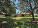 Backyard featuring a large grassy area with mature trees and a patio at 2585 Woodside Ridge Dr, Apopka, FL 32712