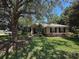 Single-story home featuring a well-maintained lawn and lush, mature trees at 2585 Woodside Ridge Dr, Apopka, FL 32712