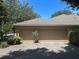 Attached three-car garage with paver driveway and lush landscaping at 2585 Woodside Ridge Dr, Apopka, FL 32712