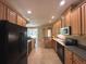 Well-lit kitchen features dark appliances, tile flooring, and plentiful cabinet space at 2585 Woodside Ridge Dr, Apopka, FL 32712