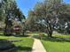 Beautiful community park with a gazebo, walking path, large trees, and lush green grass at 2585 Woodside Ridge Dr, Apopka, FL 32712