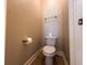 Powder room featuring a tiled floor, toilet, and convenient paper holder at 2585 Woodside Ridge Dr, Apopka, FL 32712