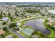 Expansive aerial view showcasing a neighborhood with lakes, mature trees, and community amenities, including a pool and tennis courts at 2888 Middleton Cir, Kissimmee, FL 34743