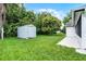 Landscaped backyard with lush green lawn, trees, and a storage shed at 2888 Middleton Cir, Kissimmee, FL 34743