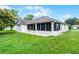 Exterior view of the home's backyard with sunroom and landscaped lawn at 2888 Middleton Cir, Kissimmee, FL 34743