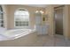 Large bathroom with dual windows, a separate shower, a jacuzzi tub, and a vanity, providing a spa-like experience at 2888 Middleton Cir, Kissimmee, FL 34743