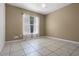 Neutral bedroom with tile floors, ceiling fan, sheer white curtains, and a large window for natural light at 2888 Middleton Cir, Kissimmee, FL 34743