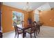 Bright dining room with natural light, classic wood dining table, and views of the lush landscaping outside at 2888 Middleton Cir, Kissimmee, FL 34743