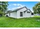 Side exterior of home showcasing the well-maintained lawn and white stucco contrasted by black window trim at 2888 Middleton Cir, Kissimmee, FL 34743