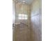Walk-in shower stall with tan tiling, glass block window, and grab bar at 2888 Middleton Cir, Kissimmee, FL 34743