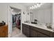 Bathroom with double sinks, and a door leading to a walk-in closet at 3077 Nottel Dr, St Cloud, FL 34772