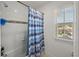 Bright bathroom with a tiled shower, window, and a white tile surround tub at 3077 Nottel Dr, St Cloud, FL 34772