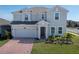 Inviting two-story home with a well-manicured lawn, beautiful landscaping, paver driveway, and attached garage at 3077 Nottel Dr, St Cloud, FL 34772