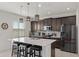 Modern kitchen featuring a spacious island with seating, dark cabinetry, and stainless-steel appliances at 3077 Nottel Dr, St Cloud, FL 34772