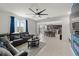 Open concept living room and kitchen, featuring tile floors, stainless appliances, and a modern ceiling fan at 3077 Nottel Dr, St Cloud, FL 34772