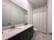 Bathroom featuring dual sinks, dark cabinets, and a shower with a white curtain at 5161 Kingwell Cir, Oviedo, FL 32765