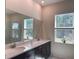 Modern bathroom with double vanity, a large mirror, and a sunlit window over the sink at 5161 Kingwell Cir, Oviedo, FL 32765