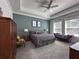 Comfortable bedroom featuring soft gray carpet, natural light, and a decorative tray ceiling at 5161 Kingwell Cir, Oviedo, FL 32765