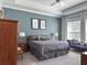 Relaxing bedroom with plush gray carpeting, a ceiling fan, and a decorative tray ceiling at 5161 Kingwell Cir, Oviedo, FL 32765