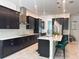 Contemporary kitchen featuring black cabinets, island with bar, and stainless appliances at 5161 Kingwell Cir, Oviedo, FL 32765