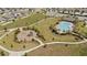 Aerial view of a community park featuring a pool, playground, walking paths, and green space at 5291 Meredrew Ln, St Cloud, FL 34771