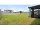 Large grassy backyard featuring a privacy fence and a partially covered patio at 5291 Meredrew Ln, St Cloud, FL 34771