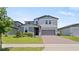 Charming two-story home with gray siding, manicured lawn, brick driveway and two-car garage at 5291 Meredrew Ln, St Cloud, FL 34771