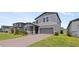 Well-maintained two-story home with a two-car garage, red brick driveway and manicured lawn at 5291 Meredrew Ln, St Cloud, FL 34771